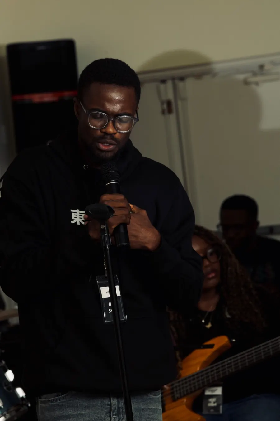 A man with glasses singing into a microphone